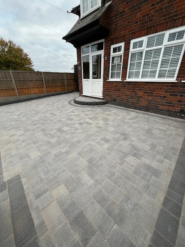 Grey block paved driveway in front of a Leicester house with herringbone laying pattern.