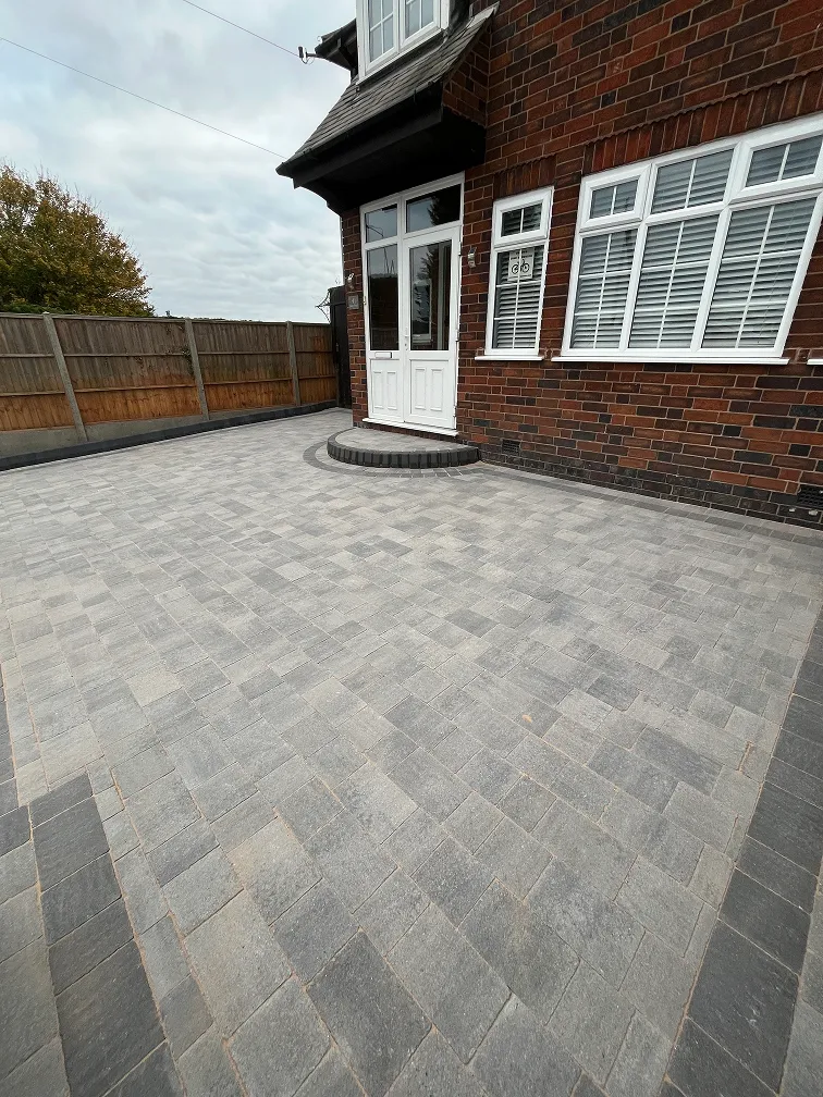 Grey block paved driveway in front of a Leicester house with herringbone laying pattern.